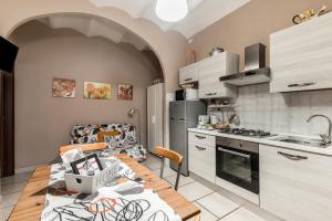 a kitchen with a wooden table and a kitchen with a counter at Vecchio Treno guest house in Tivoli +13 photos
