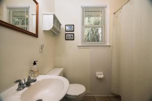 Un baño con lavabo, inodoro y espejo. en Rich Tymes, en Edisto 17 fotos más