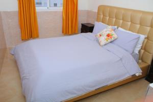 a bedroom with a large bed with orange curtains at BOUZNIKA Appartement avec piscine in Bouznika +24 photos