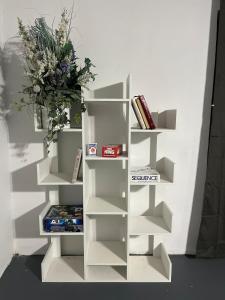 a white book shelf with a vase on it at The Jefferson Suite in Eagle Pass