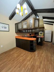 a kitchen with an orange counter top and wooden floors at The Jefferson Suite in Eagle Pass