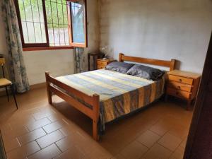 a bedroom with a bed and a table and a window at Chalet Angelica Las Toninas in Las Toninas