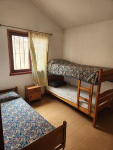 a bedroom with two bunk beds and a window at Chalet Angelica Las Toninas in Las Toninas