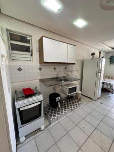 a kitchen with a stove and a refrigerator at Apartamento com churrasqueira em jurerê in Florianópolis +11 photos