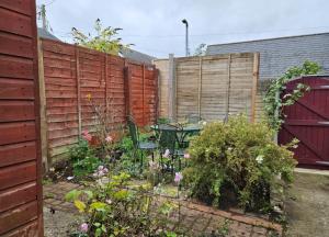 a garden with a fence and a table and chairs at B&B Rooms in terraced house in Sudbury centre in Sudbury