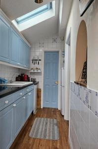 a kitchen with blue cabinets and a blue door at B&B Rooms in terraced house in Sudbury centre in Sudbury