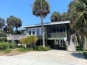 a palm tree in front of a house with palm trees at Foster's Ocean View in Edisto Island