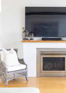 Una sala de estar con una silla y una chimenea. en Beachfront Haven Magenta, en Magenta