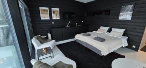 a small bedroom with a bed and a chair at Riverside villa with sauna and jacuzzi in Rovaniemi +21 photos