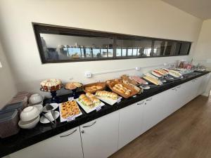 a buffet line with many different types of pastries at ORA Beach Residence by AFT in Porto De Galinhas