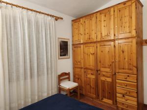 une chambre avec des armoires en bois et un lit et une chaise dans l'établissement Villetta Sunrise 21, à Costa Rei