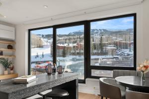 een keuken met een groot raam met uitzicht op een skigebied bij Modern 2 Bedroom Ski In&Out Condo 05 in Snowmass Village +17 foto's