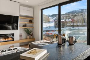 een woonkamer met een groot raam met uitzicht bij Modern 2 Bedroom Ski In&Out Condo 05 in Snowmass Village