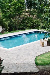 a swimming pool with blue water in a yard at Hosteria Cananvalle in Ibarra