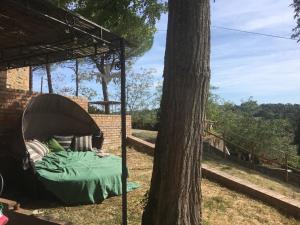 a bed under a tent next to a tree at 2 Br,1bath with 2 AC units, garden apt in Chianti! in La Collina