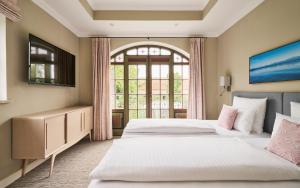 two beds in a room with a window at Hotel Gutsgasthof Stangl in Neufarn