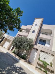 a large white building with trees in front of it at Ferienwohnung Nabeul in Douane