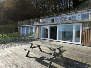 a wooden picnic table sitting on a deck in front of a house at Millendreath Oean View Villa in Saint Martin +12 photos