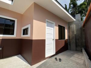 a house with a white door and a wall at Cozy Home in Dipolog by Aveinz in Dipolog