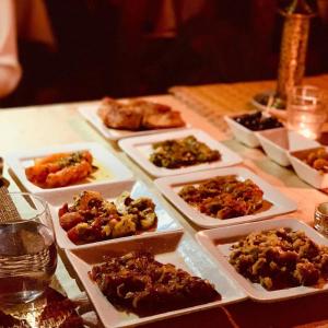 a table with many plates of food on it at Sunrise Dunes Luxury Camp in Merzouga