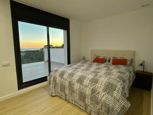 a bedroom with a bed and a large window at Les Flors de Cunit Villa Edelweiss in Cunit +42 photos