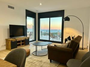 a living room with a tv and a couch and a table at Les Flors de Cunit Villa Edelweiss in Cunit
