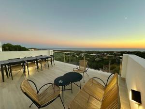 a balcony with chairs and tables on a building at Les Flors de Cunit Villa Edelweiss in Cunit