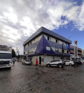 クルーズ・ダス・アルマスにあるFlat Centralの駐車場に車が駐車されている大きな建物