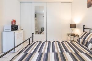 a bedroom with a bed and a refrigerator at Chambre calme, zen & lumineuse in Sevran +1 photo