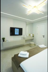 een witte kamer met een tv aan de muur bij VS Gold Apartament in Galaţi