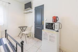a microwave sitting on top of a refrigerator next to a door at Chambre calme, zen & lumineuse in Sevran