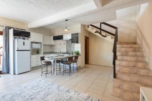 ItajubáにあるCasas completas em condomínio com piscina a 110m do Mar - ONIsのテーブルと椅子のあるキッチンとダイニングルーム