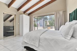 ein Schlafzimmer mit einem weißen Bett und einem großen Fenster in der Unterkunft Villa Picasso - 3 Bed Villa in Johannesburg + 10 Fotos