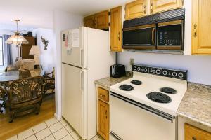 y cocina con fogones blancos y nevera. en Oasis #18 Daytona Beach Shores Retreat-Walk To The Beach, en Daytona Beach Shores