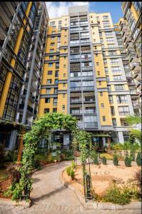 a large yellow building with trees in front of it at Studio apartment in Gatunga