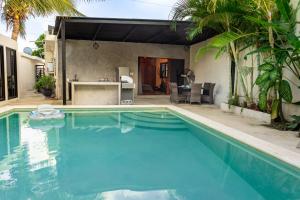 a swimming pool in front of a house at Casa NAJ BALAM in Bacalar