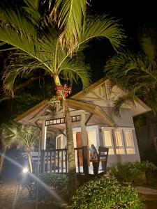 a house with a palm tree in front of it at Lanta Palm Beach Resort , Beach Bungalow - Koh Lanta in Ko Lanta