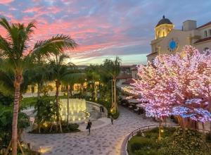 a building with a clock tower and palm trees at Steps To Beach! 4 Condos In 1- Perfect For Groups in West Palm Beach