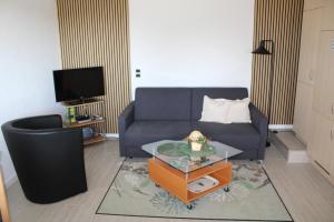 a living room with a blue couch and a table at Ferienwohnung Kaiser in Reifferscheid