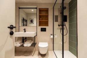 a bathroom with a toilet and a sink and a shower at Leworth Apartments, Windsor in Windsor