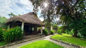 a house with a thatched roof and a garden at Senda Beach House Tayrona in Buritaca