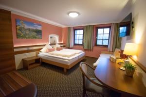 エンマースドルフ・アン・デア・ドナウにあるWirtshaus Gruber Weiteneggのベッドと机があるホテルの部屋