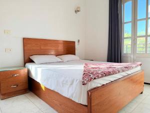a bedroom with a large bed with a wooden headboard at Nile View House in Luxor +139 photos