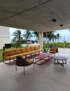 un groupe de bancs et de tables sur un patio dans l'établissement Apartamento pé na areia, à Ilhéus