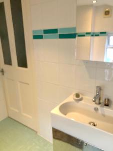 Un baño blanco con lavabo y puerta. en Trendy Terrace, en Bristol