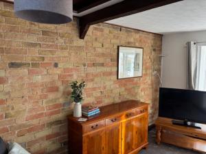 Televiisor ja/või meelelahutuskeskus majutusasutuses Cottage 1, a Cosy Retreat with Secure Parking +7 fotot