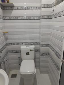 a bathroom with a white toilet and a sink at AJA Manzil in Watumulla