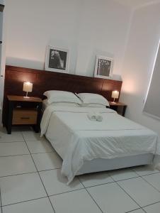 リオデジャネイロにあるCondo ipanema 209の大きなベッドと2つのナイトスタンドを備えた寝室