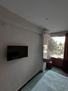 Una sala de estar con un televisor de pantalla plana en una pared. en The Pyramid Vault View INN, en El Cairo