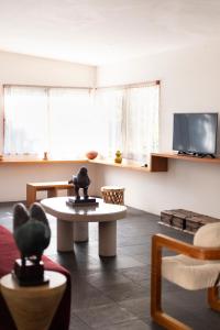 a living room with a table and a tv at Casa Chavela in Tepoztlán